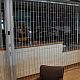 Classic Chainlink sliding folding security shutter in front of servery at airport.