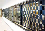 a long black sliding shutter with an alternating pattern of open and closed squares in front of a food servery