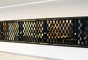 A black sliding shutter, seen from the right-hand side, with sqyare openings that you can see through