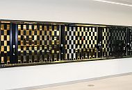A black sliding shutter, seen from the left-hand side, with sqyare openings that you can see through