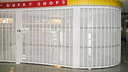 Detail of a curve of a sliding security shutter with perforated curtain