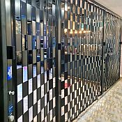 Sliding security shutter in black with a patterns of open and closed squares