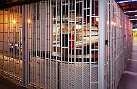 Detail of sliding security shutter folding around the 90 degree corner of a bar