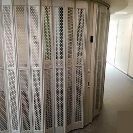 Sliding security shutter with small punched out holes which show the reception desk behind it shining through