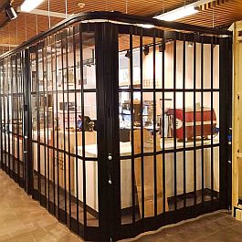 Sideview of a black FlexiGlide Vision Glass sliding shutter closing off a cafeteria.