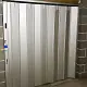 Anodised aluminium sliding shutter closing off a doorway in a concrete brick wall