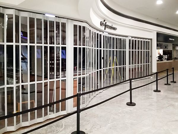 A long, glazed sliding security shutter closing off the entrance to a cafe restaurant