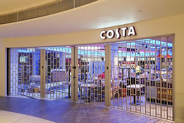 Sliding folding security shutter at a wide and curved shopping centre storefront.