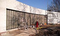 a very long sliding shutter in a curved brick wall
