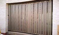sliding security shutter following a shallow curve in a brick wall